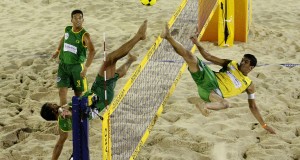 2 guys playing after ball over volleyball net with feet footvolley basic equipment ball and beach volleyball net